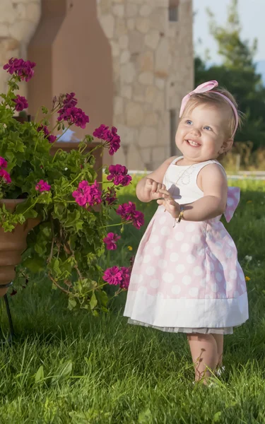 Солодка дівчинка грає з квітами на відкритому повітрі — стокове фото