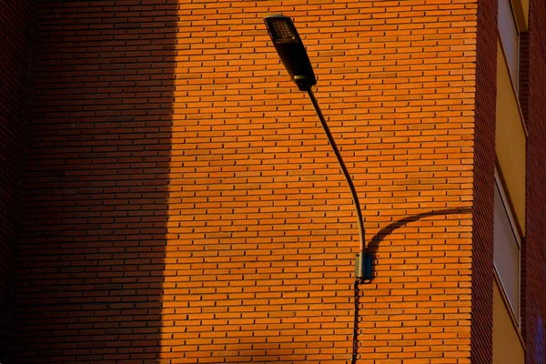 Een Diep Rode Bakstenen Muur Ondersteunt Een Lantaarnpaal Contrasterende Heldere — Stockfoto