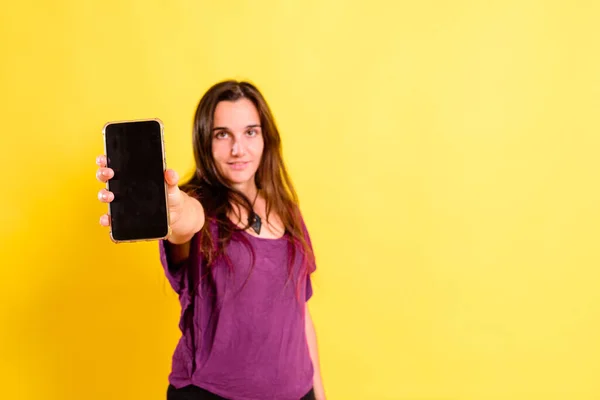 Aislado Fondo Amarillo Del Estudio Una Mujer Joven Sostiene Teléfono — Foto de Stock