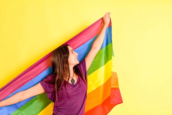 Mujer Joven Portando Una Bandera Arco Iris Lgbt Aislada Sobre —  Fotos de Stock