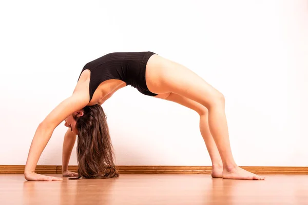 Hermosa Joven Traje Oscuro Realiza Poses Yoga Una Habitación Blanca — Foto de Stock