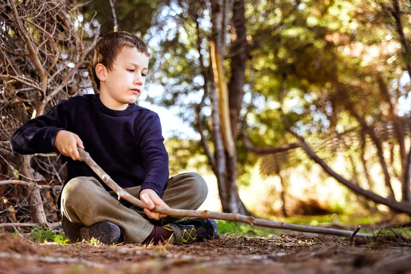 Ένα Παιδί Που Κάθεται Στο Έδαφος Ένα Δάσος Χρησιμοποιεί Ένα — Φωτογραφία Αρχείου