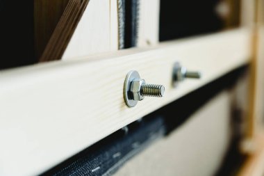 Vidalar, fındıklar ve çamaşır makineleri bir mobilyanın içinde ahşap kalasları tutuyor..