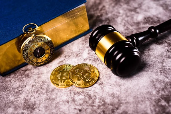 Bitcoin regulated by international monetary laws, gold coin next to gavel.