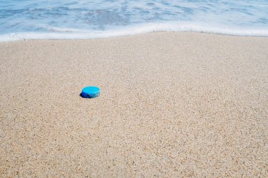 Sahile çöp ve plastik atan, kirleten ve kirleten tatilcileri teşvik eden bir fotoğraf..