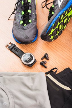 Valencia, İspanya - 9 Mayıs 2021 Brooks koşu ayakkabıları ve Garmin spor saati, spor malzemelerinde en iyi markalar, bir atletizm yarışından önce yerde..