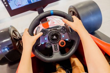 Valencia, İspanya - 16 Nisan 2021: Çocuk bir Playstation araba video oyun kontrolöründe direksiyon kullanıyor.