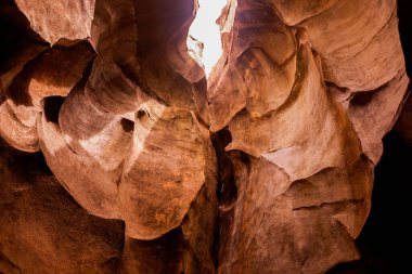 İçinden ışık filtresi geçen bir mağaranın içi, aşınmış kumtaşı kayaları.