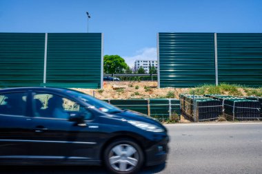 Valencia, İspanya - 9 Haziran 2021: Komşu evleri gürültüden izole etmek için gürültülü bir yolun yanında inşaat malzemeleri.