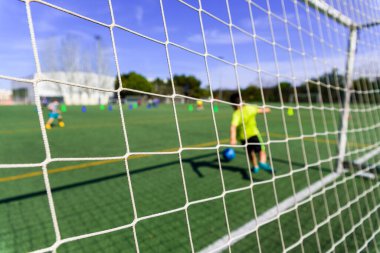 Bir goldeki futbolcu metin için kopya alanı olan bir topu, arkaplanı durdurmaya çalışır.