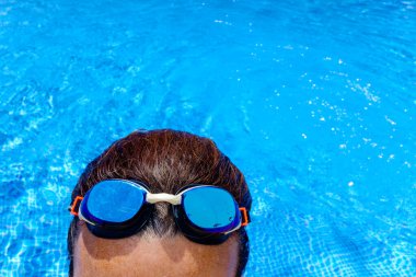 Yazın havuzda yüzen bir kadın gözlüğü..