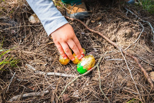 Χέρι Ενός Κοριτσιού Συλλέγει Πασχαλινά Σοκολατένια Αυγά Κρυμμένα Στον Κήπο — Φωτογραφία Αρχείου