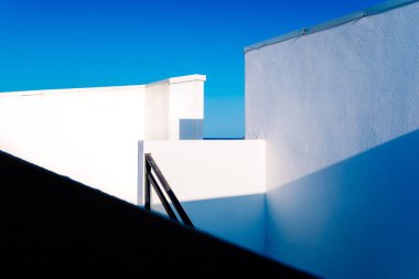 Akdeniz tarzı evlerde beyaz duvarlar, basit ve temiz tasarlanmış geometrik açılı şekiller..