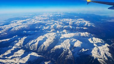 Hava görüntüsü, kar kaplı Pireneler 'in açık gökyüzünün altındaki dağları gösteriyor. Manzara, metin eklemek veya doğal manzarayı keşfetmek için ideal geniş bir perspektif sunar..