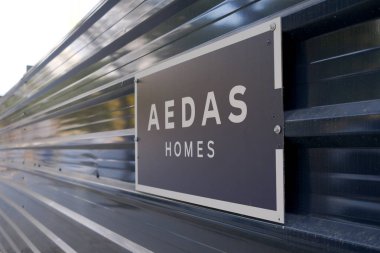 Valencia, İspanya - 18 Ocak 2025: İnşaat tabelasında inşaat alanının yakınında fotokopi alanı ve bulanık arkaplan bulunan şirket ismi gösteriliyor