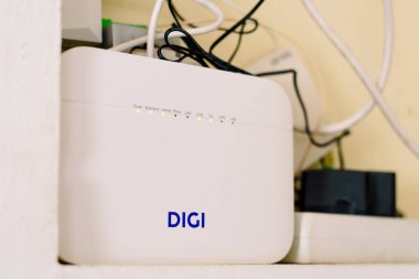 Valencia, İspanya - 28 Ocak 2026: Yönlendirici DIGI ve internet kabloları metin için fotokopi alanı ve bulanık arkaplan içeren küçük bir çalışma alanı içinde