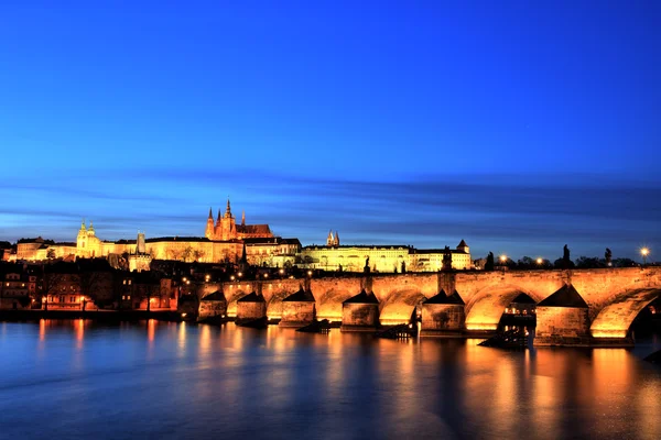 Подсвеченный Карлов мост с Пражским градом на закате, Прага — стоковое фото