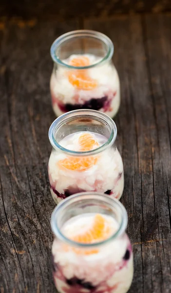 Yogurt with blueberries and orange in glasses — Stock Photo, Image