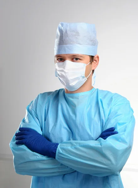 Mavi elbise, şapka ve maske giymiş genç doktor silah ile geçti