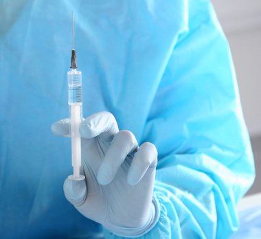 Masada oturan ve şişe tutan erkek doktor