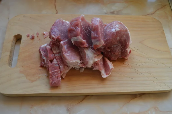 Bifes de porco crus em uma tábua de corte — Fotografia de Stock