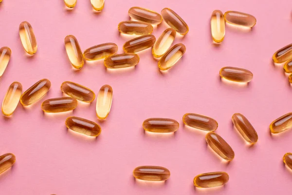 Vitaminler Omega 369 balık yağı, D vitamini sağlık yaşam tarzı üst görünümü için pembe arka planda.