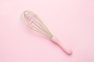 Pembe arka planda çok renkli pastel mutfak çırpıcısı, sevimli mutfak aletleri, kadınsı üst görünüm.