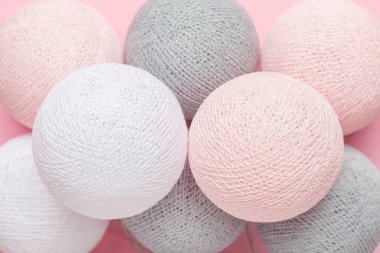 Pastel arka planda pembe, gri ve beyaz toplar, ev dekorasyonu üst manzara.