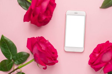 Cep telefonu ve gül çiçekleri pembe pastel arka plan görünümünde