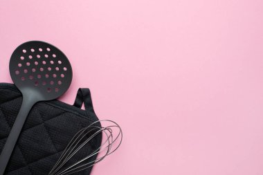 Pembe arka planda mutfak aksesuarları spatula çırpışı, kopyalama alanı üst görüşlü kadın yemekleri.