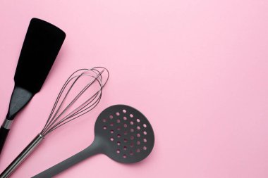 Pembe arka planda mutfak aksesuarları spatula çırpışı, kopyalama alanı üst görüşlü kadın yemekleri.