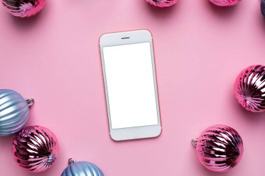 Cep telefonu ve Pembe arka plan görünümünde dekorasyon için parlak Noel mavi ve pembe toplar