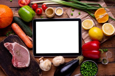Elektronik tablet beyaz ekran et ve farklı sebzeler ile ılıman ahşap arka plan görünümlü