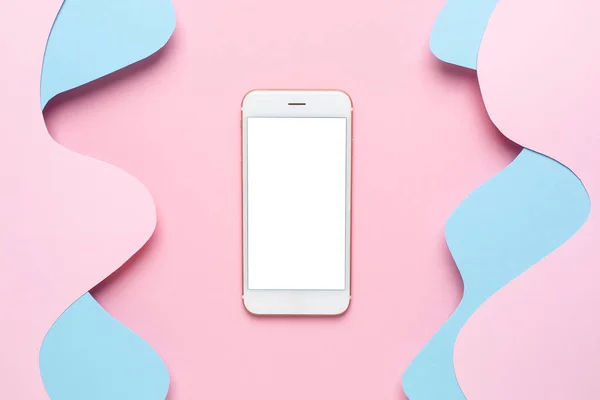 Mobile phone and Abstract paper cut blue waves art on pink background, pastel colors and technology top view