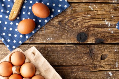 Kahverengi tavuk yumurtaları ahşap bir arka planda paketlenmiştir, evde fotokopi odası manzaralı pişirilmektedir.