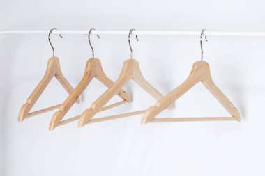 Beyaz arka planda izole edilmiş birçok ahşap askı. Dükkan konsepti, satış, tasarım, boş askı kenarı görünümü