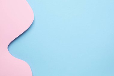 Farklı soyut kağıt katmanları ve pastel pembe arkaplan üzerinde mavi dalgalar telif alanı üst görünümü ile