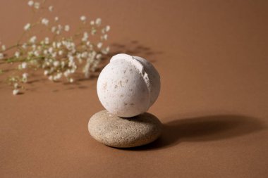Vanilya aromalı banyo bombası, kaplıca kompozisyonu, kuru çiçekler ve kahverengi arka planda taş. Aromaterapi düzenlemesi, zen natürmort yaşam, sağlık ve vücut bakımı, gölge görüşlü trend kavramı