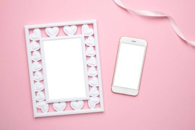 Sevgililer Günü kompozisyonu. Kalpli fotoğraf çerçevesi ve pastel pembe arka planda cep telefonu. Düğün için. Doğum günü. Mutlu kadınlar günü. Anneler Günü. Düz konum, boşluk üst görünümünü kopyala