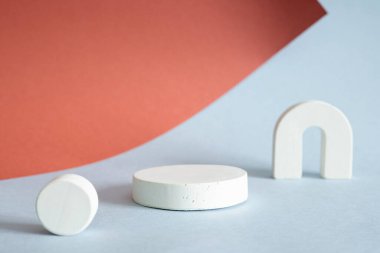 Açık mavi ve kırmızı kahverengi arka planda beyaz podyum. Kozmetik ürün sunumu için boş vitrin, promosyon