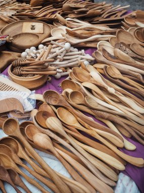 Tahta kaşıklar süs eşyasıyla yüzeyde yatar. Klasik tarzda çeşitli ahşap çatal bıçaklar. Ev aletleri adil dikey görünümde satılır.