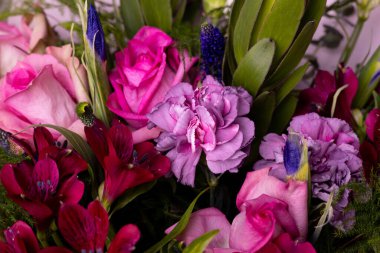 Bir buket pembe İngiliz gülü, lale, karanfil ve yeşil yan görüş.