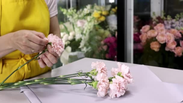 花店里的女花匠在花卉设计工作室里 一个女人正在做一束美丽而时尚的粉红色鲜花 4K侧视图 — 图库视频影像
