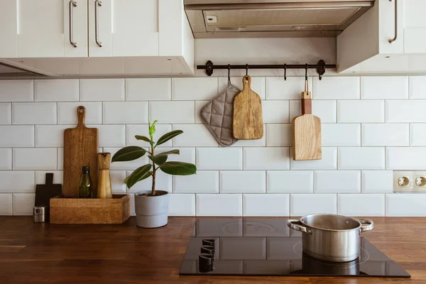 Bir tencerede kaynar su ve modern beyaz mutfakta indüksiyon sobasında bir tava. 