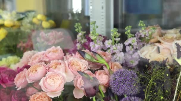 Bir çiçekçi - vitrin standı yaz pazarında farklı renklerde harika çiçeklerle dolu. Satılık vazolarda birçok çiçek var.. — Stok video