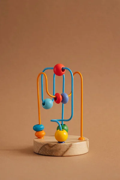 Utvecklar leksak för barn. Labyrinten av träpärlor på brun bakgrund — Stockfoto