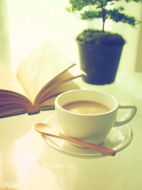 kahve açık kitap ve küçük ağaç