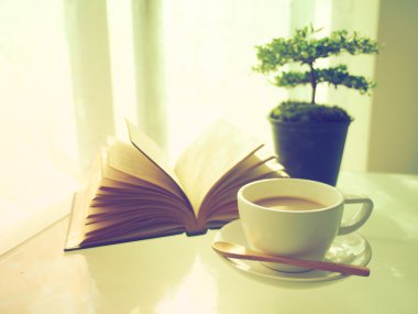 kahve açık kitap ve küçük ağaç