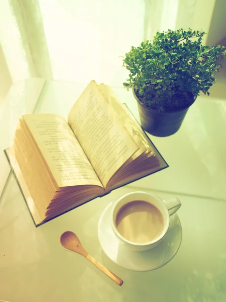 Kaffee aufgeschlagenes Buch und kleiner Baum — Stockfoto