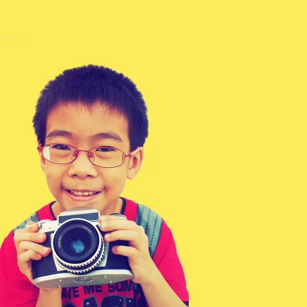 Criança jovem segurando uma câmera instantânea — Fotografia de Stock